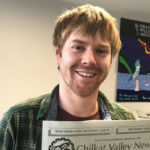 Chilkat Valley News editor Kyle Clayton holds a newspaper and smiles