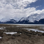 A wide river mount meets snowy mountains